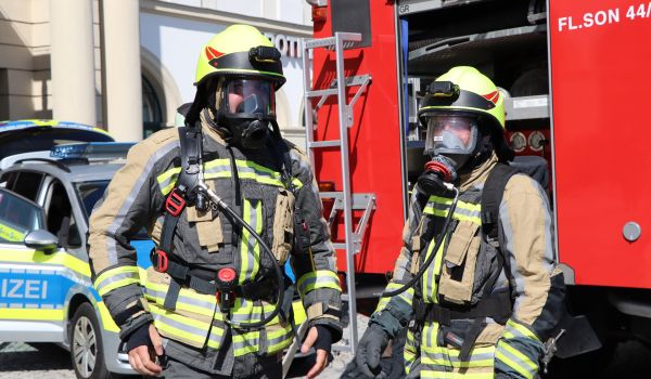 Zwei Feuerwehrmitarbeiter in voller Montur.