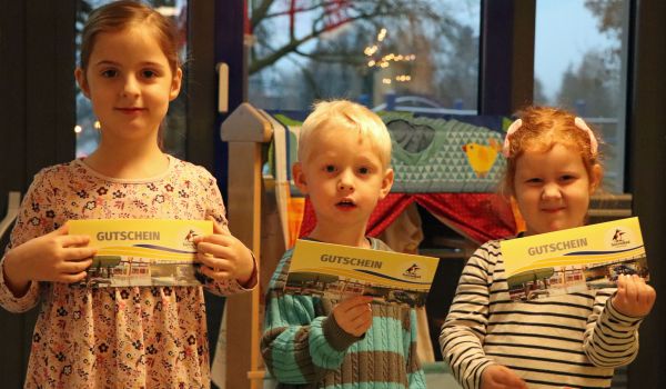 Drei Kinder stehen nebeneinander und halten SonneBad-Gutscheine in den Händen.