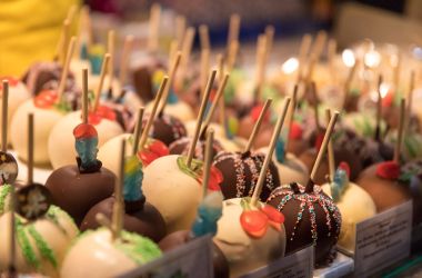 Ein beleuchteter Weihnachtsmarktstand mit Süßigkeiten.