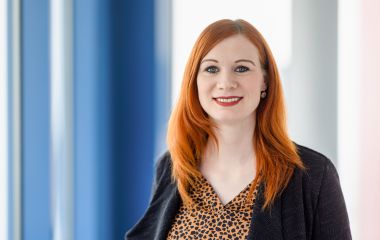 Eine Frau steht vor einem Fenster. Es ist die Bibliotheksleiterin Nicole Obermeier.