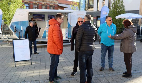 Auf einem Platz in der Innenstadt von Sonneberg stehen sechs Menschen und unterhalten sich miteinander.