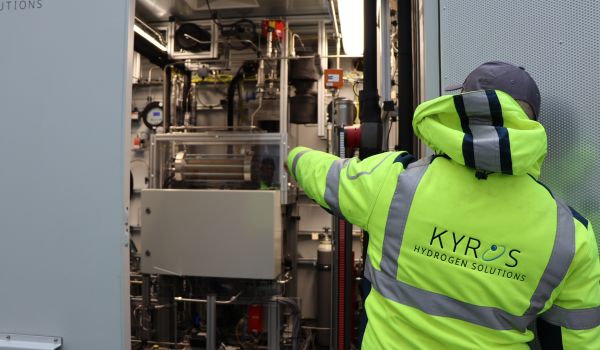 Ein Mann in Warnjacke greift in eine technische Anlage.