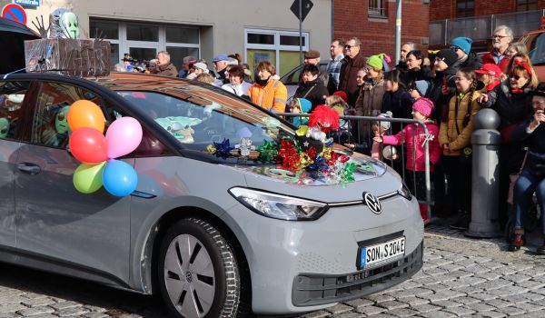 Ein bunt geschmücktes Auto fährt beim Umzug mit.