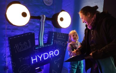 Auf einer H-förmigen Schild leuchtet das Wort ''Hydro'' blau.