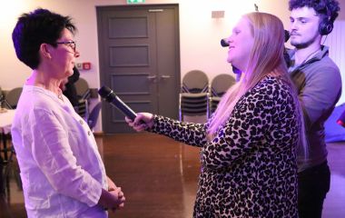 Eine Frau hält Petra Adelbert ein Mikrofon hin. Daneben steht ein Mann mit Kamera.