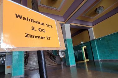 Im Foyer des Rathauses steht ein Schild mit der Aufschrift: Wahllokal 103 2. OG Zimmer 27.