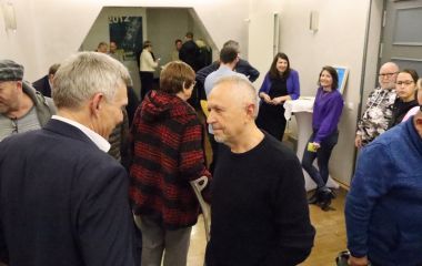 Mehrere Menschen stehen in einem Flur und unterhalten sich.