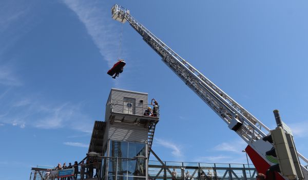 Ein Mitarbeiter der Bergrettung hängt an einer Drehleiter.