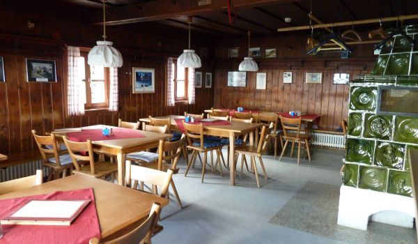 Tische und Stühle in einer Berghütte.