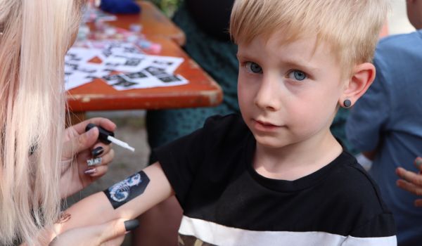 Ein Kind bekommt ein temporäres Tattoo auf seinen Arm.