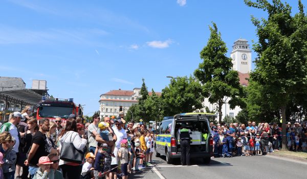 Viele Menschen stehen hinter einer Absperrung.