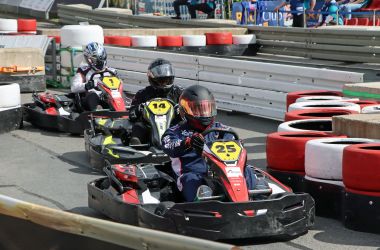 Drei Kartfahrer fahren auf der Rennstrecke.