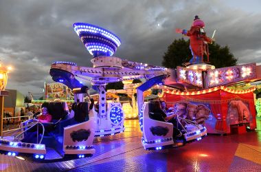 Ein Fahrgeschäft ist im dunkeln beleuchtet.