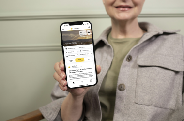 Eine Frau hält einen Handybildschirm in die Kamera.