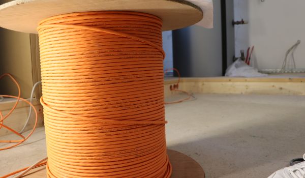 Ein große Spule mit orangem Kabel.