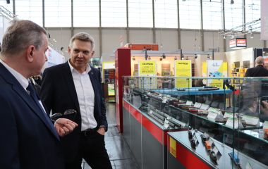 Zwei Männer stehen vor einem Schaukasten mit Modelleisenbahnen.