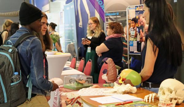 Personen stehen an einem Infostand mit biologischen Modellen.