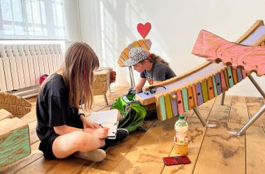 Kinder sitzen im Spielbereich des Spielzeugmuseums Sonneberg.