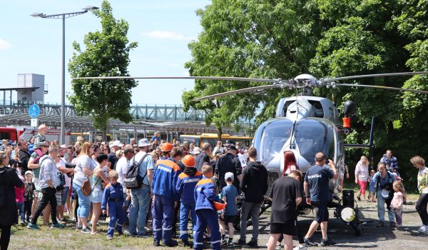 Viele Menschen schauen sich einen Polizei-Hubschrauber aus der Nähe an.