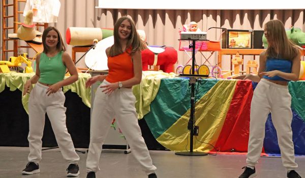 Jugendliche tanzen vor einer Bühne.