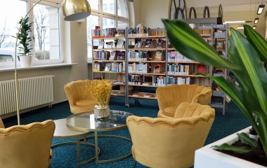 Vier gelbe Sessel stehen in einer neu eingerichteten Bibliothek.