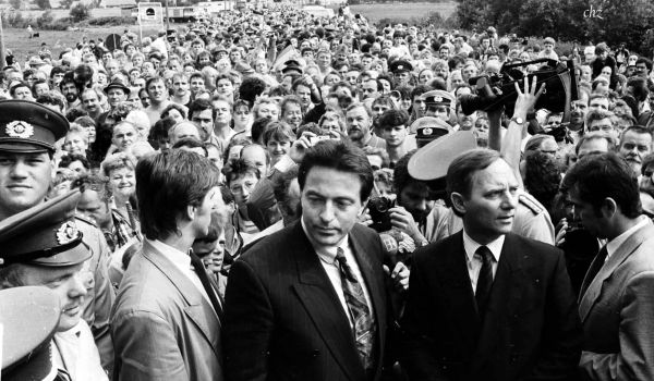 Schwarz-weiß: Viele hunderte Menschen stehen eng an eng auf der Straße.