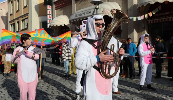 Eine Gruppe in Einhornkostümen spielt Blasinstrumente.