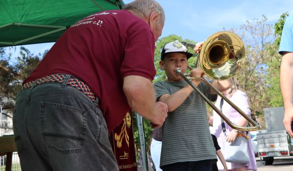 Ein Kind versucht auf einer Trompete zu spielen.