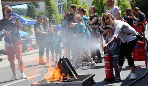 Ein Kind löscht ein Feuer mit einem Feuerlöscher.