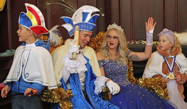 Das Prinzenpaar sitzt auf einem mit goldenem Lametta verzierten Stuhl nebeneinader.