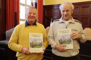 Zwei Männer halten ein Buch mit der Aufschrift: Vereinsgeschichte Höhnbach in der Hand.