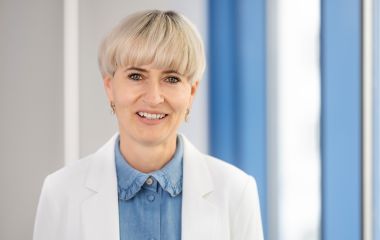 Eine Frau steht vor einem Fenster. Es ist die Sachgebietsleiterin für Soziales: Bettina Sieber.