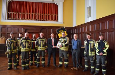 Feuerwehrkameraden stehen im Rathaussaal.