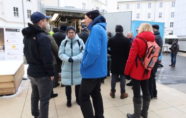 Besucher unterhalten sich vor dem Infopoint.