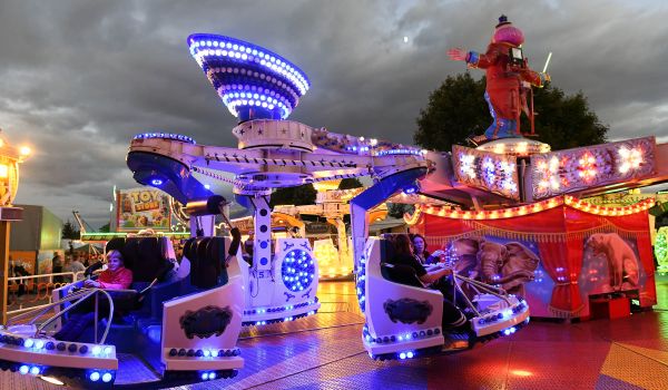 Ein Fahrgeschäft ist im dunkeln beleuchtet.