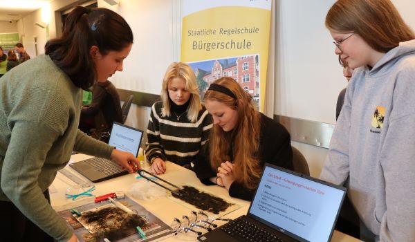 Jugendliche am Stand der Bürgerschule machen Experimente.