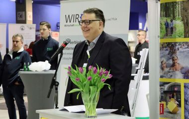 Ein Mann steht hinter einem Mikrofon.