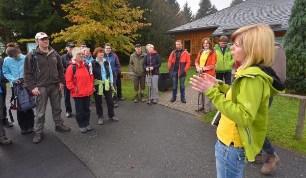 Mehrere Personen mit Wanderbekleidung stehen in einem Kreis.
