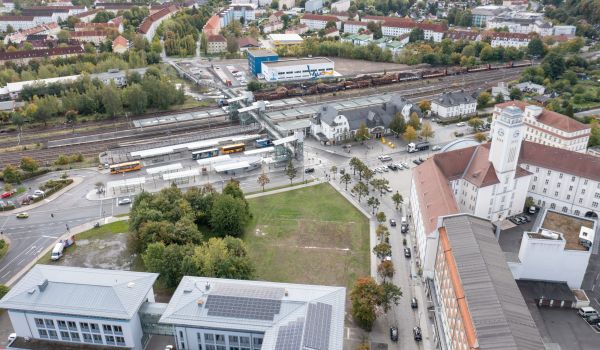 Drohnenaufnahme mit Blick auf den Bahnhof, das Rathaus und das AOK-Gebäude. Im Hintergrund ist der Stadtteil Wolkenrasen zu sehen.