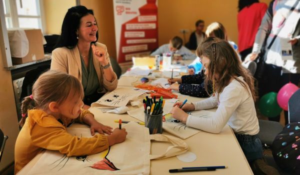 Kinder bemalen Stoffbeutel.