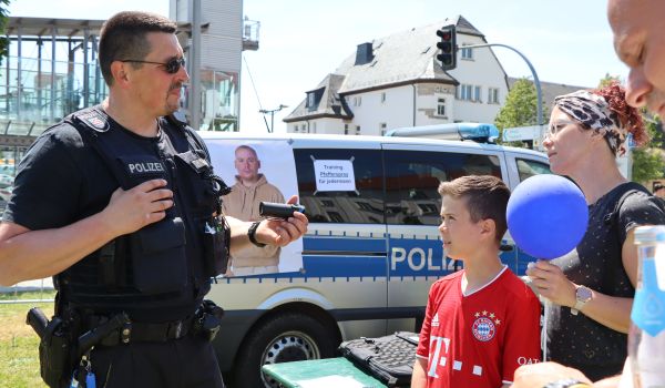 Ein Mann in Polizei-Uniform unterhält sich mit Interessierten.
