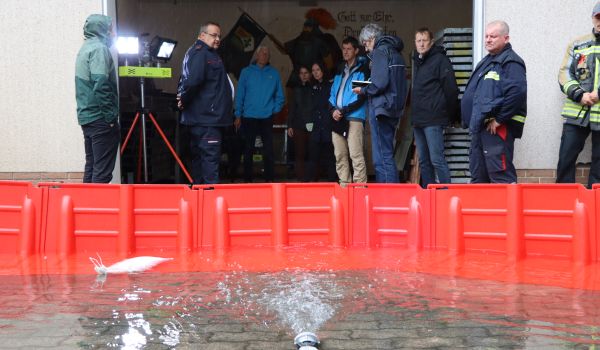 Eine mobile Barriere für Hochwasserschutz wird vor einem Gebäude getestet.