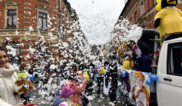 Schaum regnet auf die Zuschauer des Faschingsumzugs.