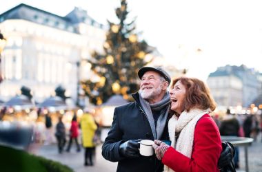 Zwei Senioren auf einem Weihnachtsmarkt.