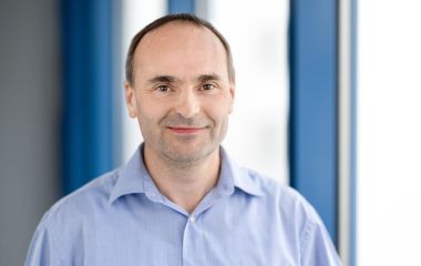 Ein Mann steht vor einem Fenster. Es ist der Sachgebietsleiter im Bereich Haushalt und Steuern: Silvio Werner.