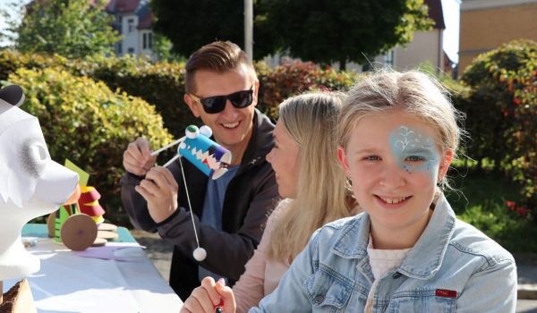 Kinder sitzen an einem Tisch. Auf dem Tisch liegen Materialien zum Basteln.