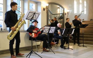 Fünf Personen musizieren im Treppenhaus.