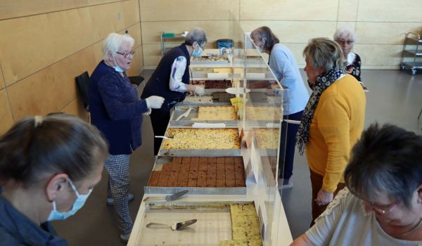 Frauen stehen an einem Kuchenbuffet.