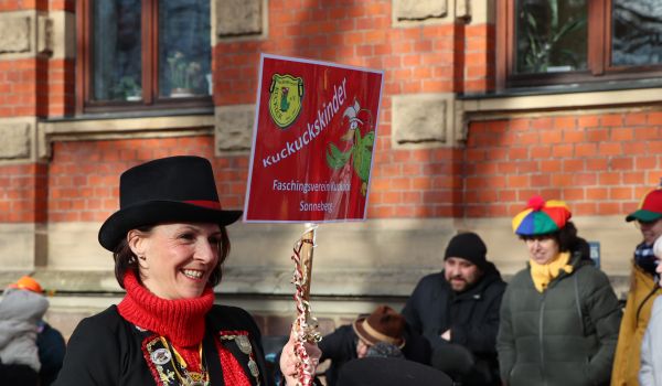 Eine Frau hält ein Schild mit der Aufschrift: Kuckuckskinder.