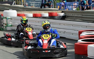 Zwei Kartfahrer fahren auf der Rennstrecke.